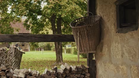 wicker basket and firewood against rustic wall in kumrovec, croatia
