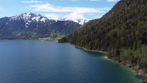 hiking trail along the lake surrounded by alps mountains