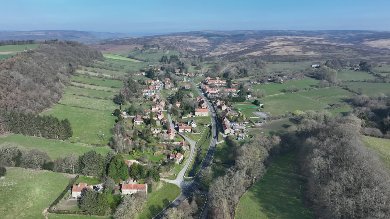 Hutton Le Hole, letecké záběry, Národní park North York Moors, nájezd k vesnici a panorámování dolů