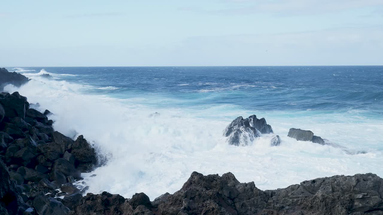 Potenti onde dell'oceano che si infrangono contro una costa rocciosa
