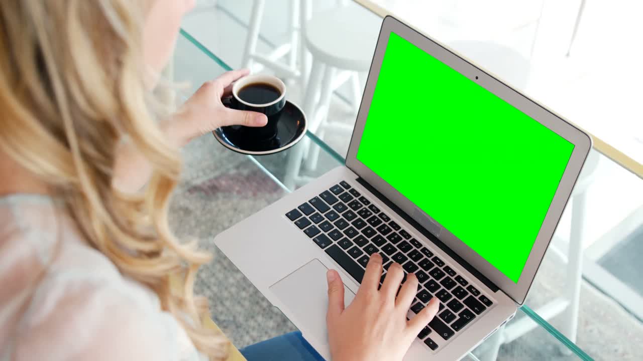 Woman using laptop while having coffee