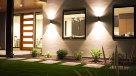 a serene nighttime landscape featuring a modern home's exterior, illuminated by soft lighting and surrounded by lush greenery and architectural elements