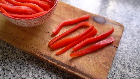 Palitos-De-Pimiento-Rojo-Sobre-Tabla-De-Madera