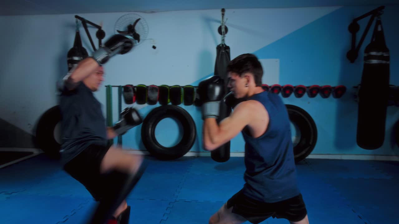 Two Men Sparring in a Martial Arts Gym