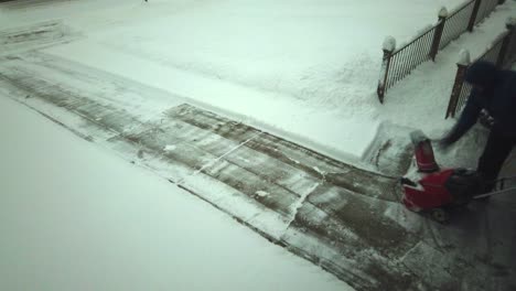 Un-Hombre-Quitando-La-Nieve-En-Su-Camino-De-Entrada-Con-Un-Soplador-De-Nieve-Hecho-En-Un-Lapso-De-Tiempo-Mientras-Lo-Limpia-Muy-Rápido