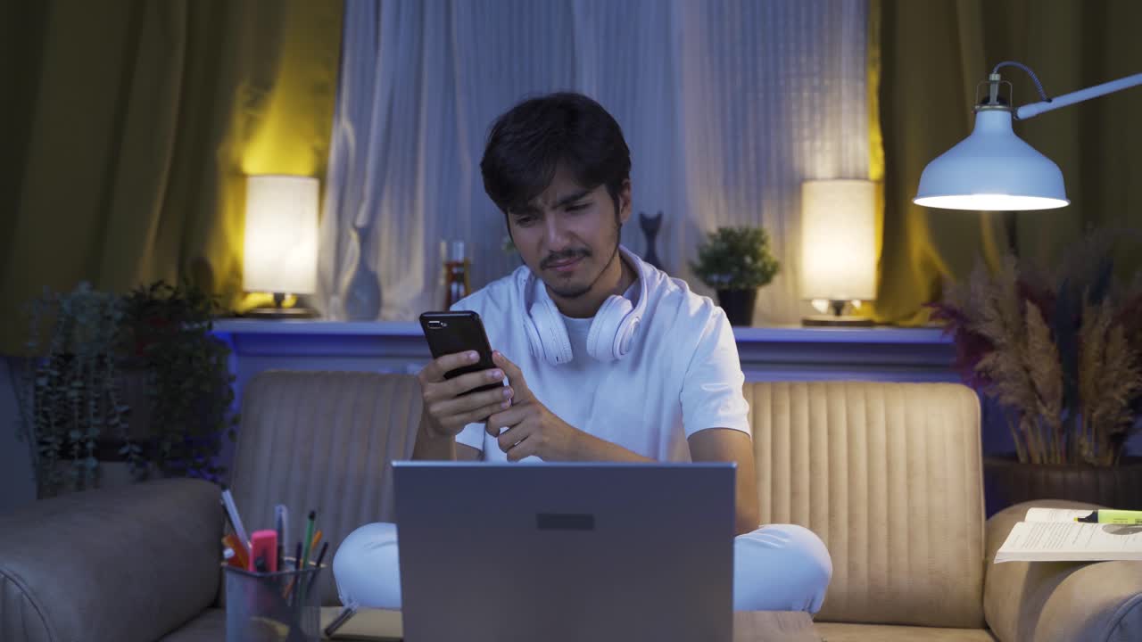 우울한 남자가 밤에 전화로 문자 메시지를 보내고 있습니다.