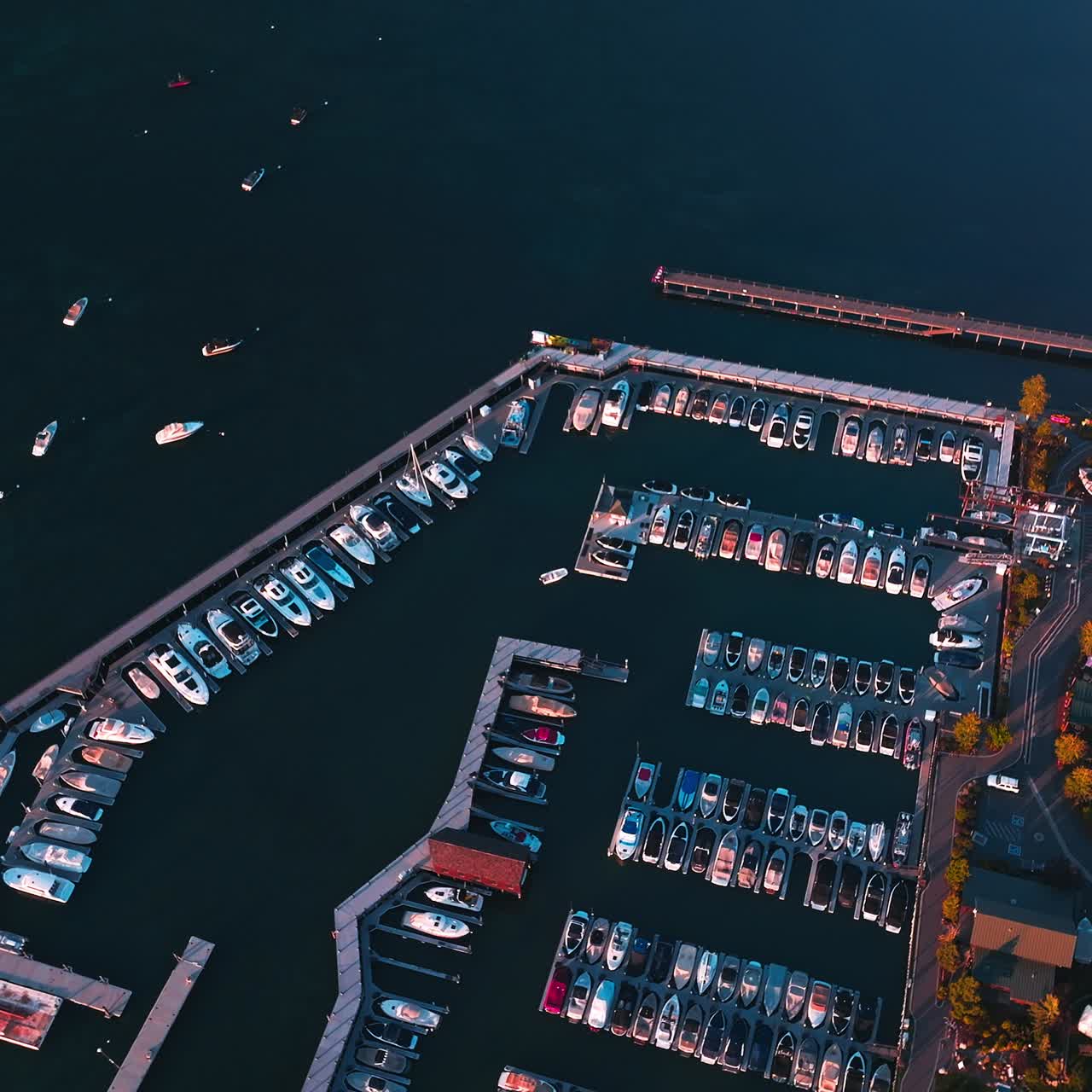Boat pier with multiple yachts. Many boats are on the lake. Beautiful bank of Lake Tahoe, California, USA. Aerial view