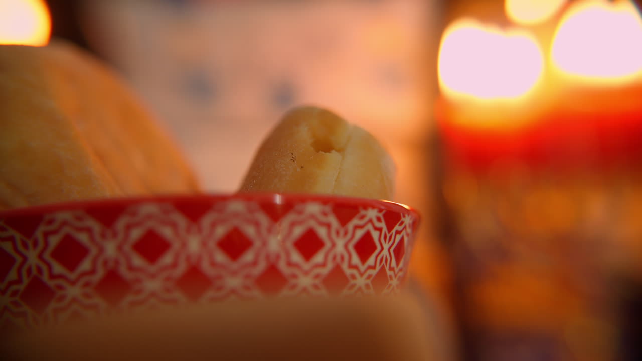 Primo piano di panini in una ciotola decorata con la morbida luce di una candela.