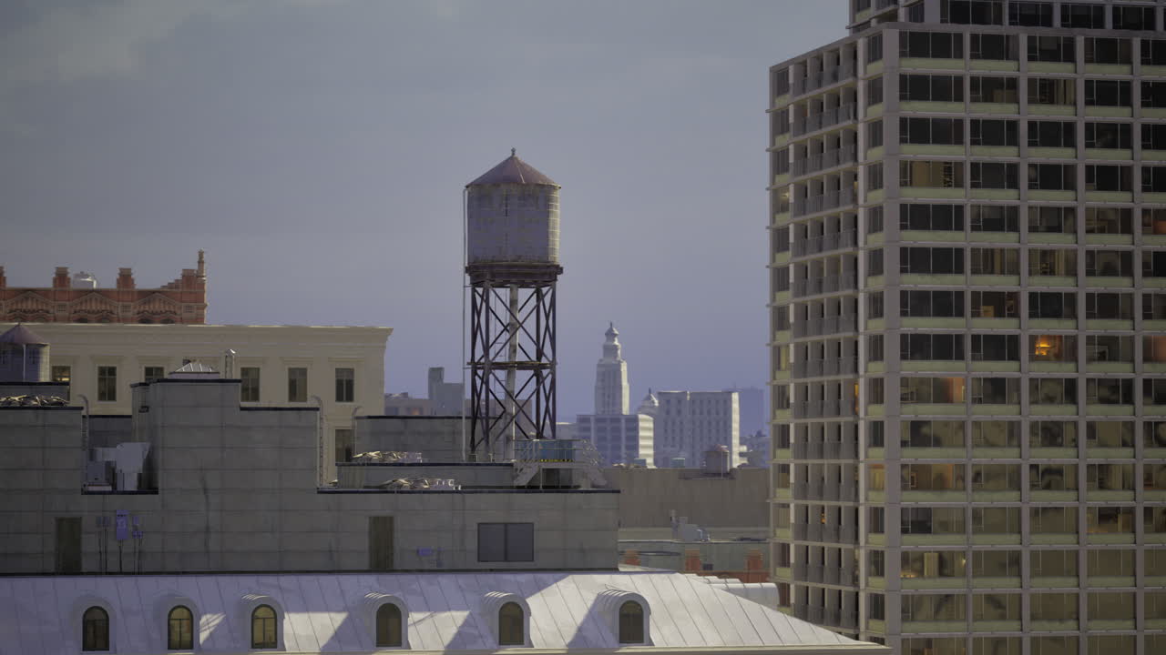Urban skyline with water tower and modern buildings at dusk