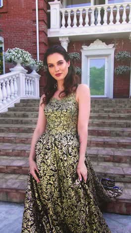 woman in a gold and black ball gown on a grand staircase