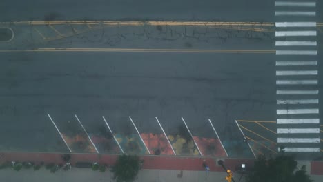 aerial top down perspective of urban buildings, sidewalks, and empty road on foggy morning