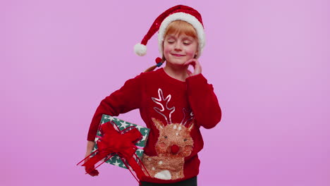 Cheerful-girl-in-Santa-sweater-presenting-two-Christmas-gift-boxes-stretches-out-her-hands-to-camera