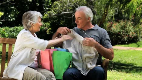 Älteres-Ehepaar-Blickt-Auf-Einer-Bank-Auf-Den-Einkauf