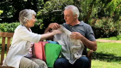 pareja de ancianos mirando las compras en un banco