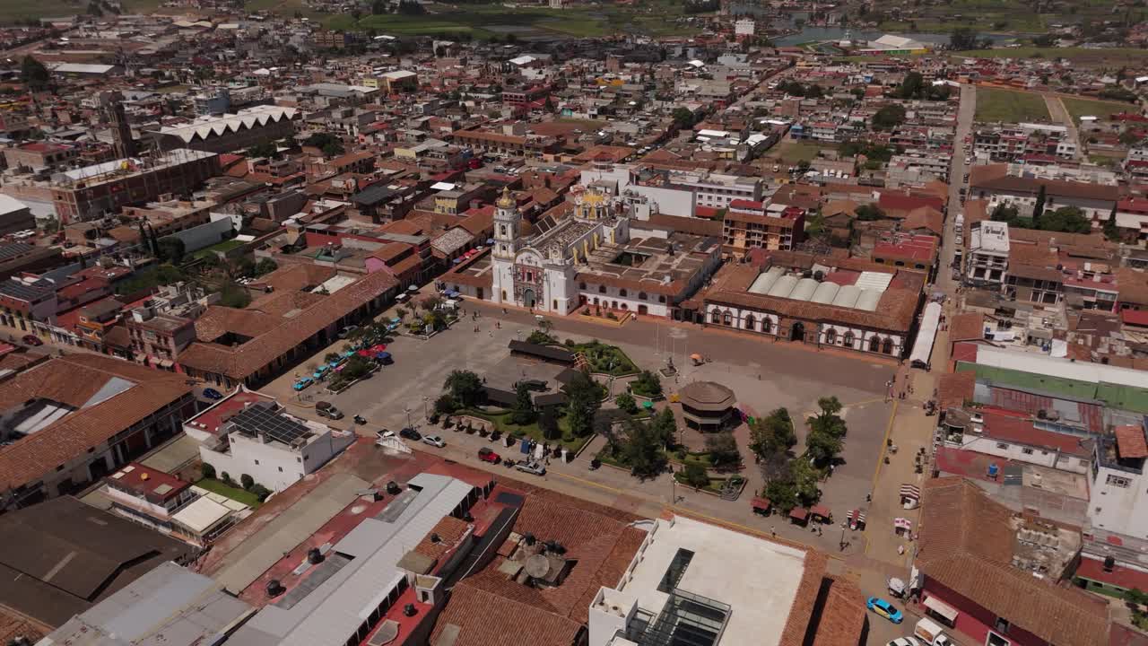 A birdseye view of the bustling market place in front of Parroquia de Santiago Apostol, showcasing vibrant activity and local culture.