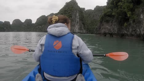 Toma-Pov-De-Una-Mujer-En-Un-Kayak,-Remando-Visto-Desde-Atrás