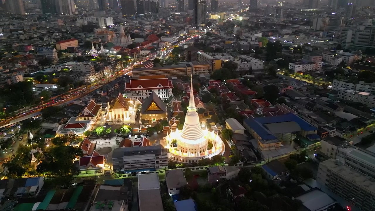 Evening dusk flyover of grand whitewash stupa Buddhist temple, Bangkok