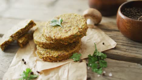 video of fresh leaves and vegetarian burgers over wooden background