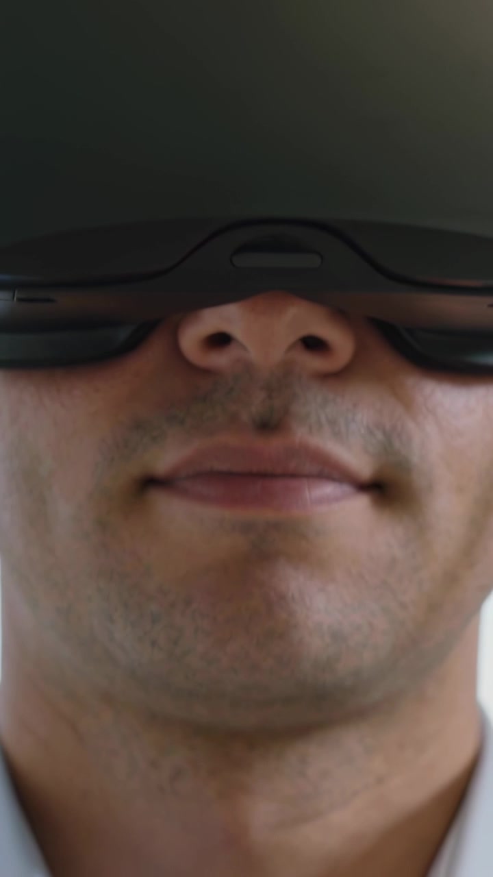 Vertical video: Ending VR session, man in black VR headset and blue shirt at home giving thumbs up