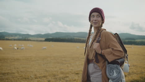 female explorer walking by cows in farm