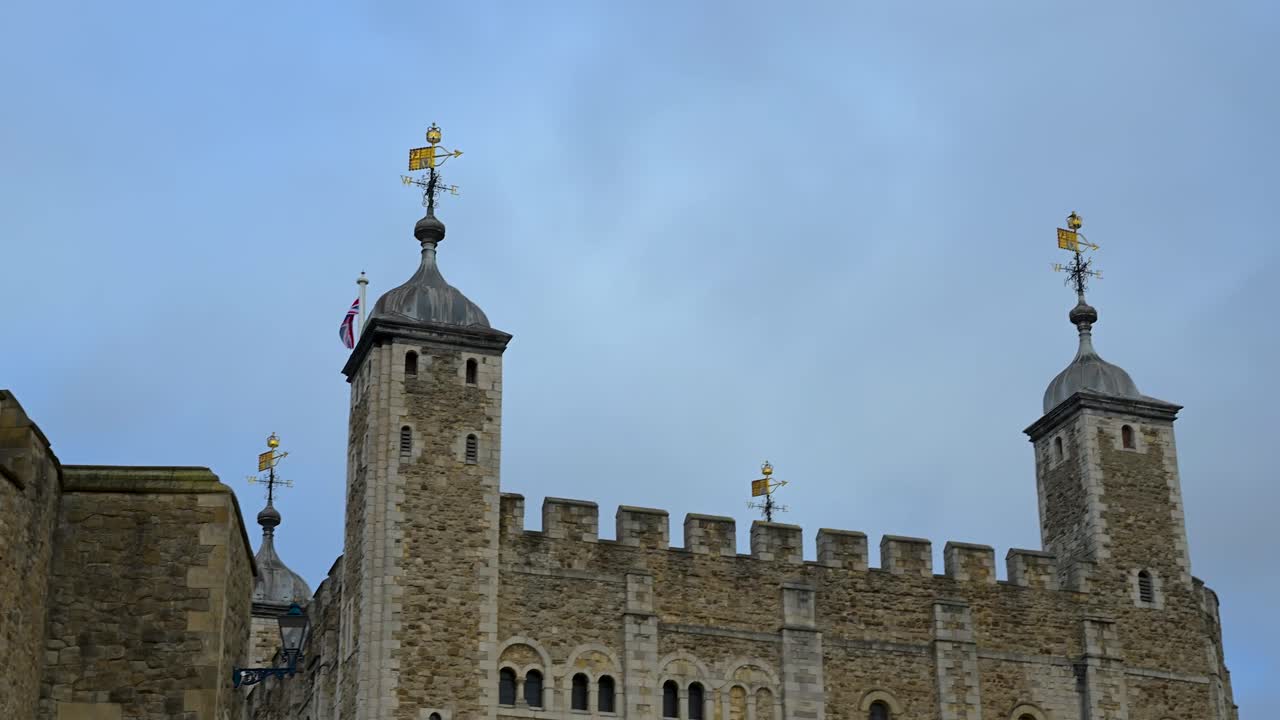 Wide view of the outer stone walls and towers of the historic fortress seen from the nearby riverside walkway