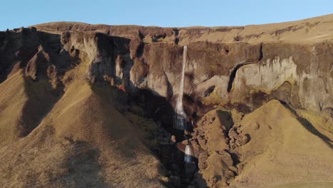 Aerial-Shot-of-a-High-Waterfall-Falling-over-a-Cliff-Edge