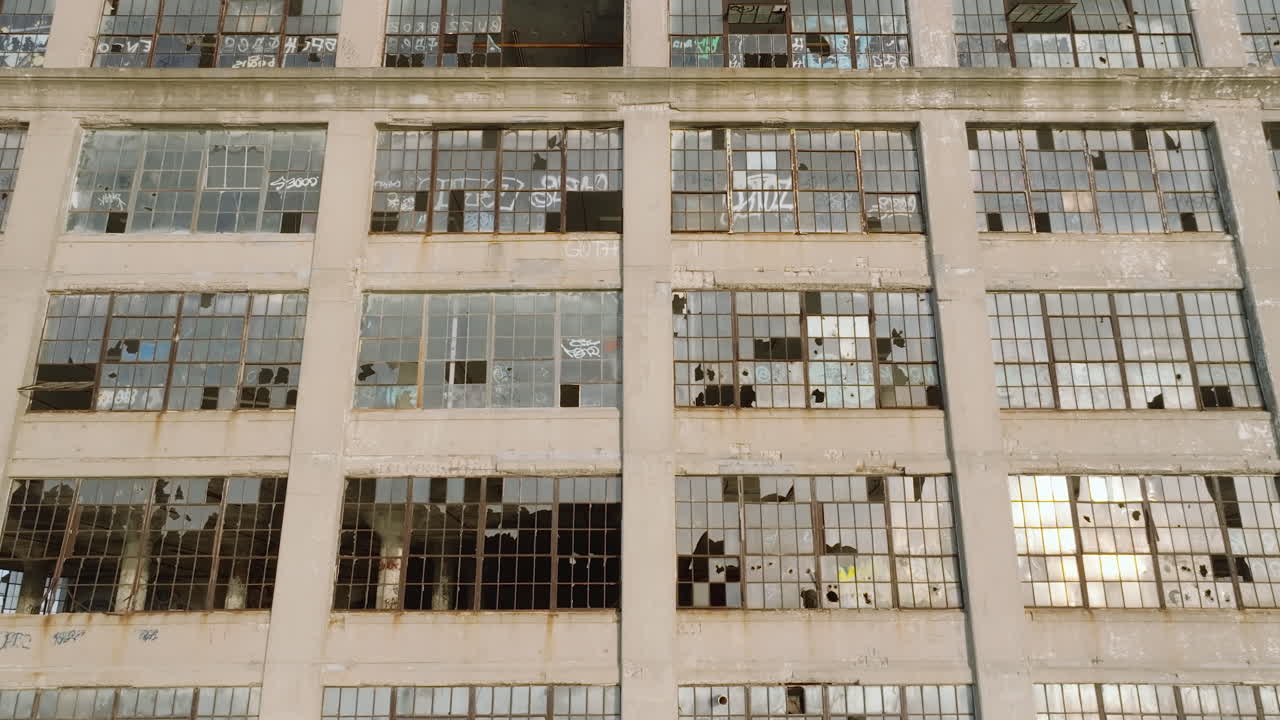 Aerial view of the exterior of an abandoned warehouse at sunset.