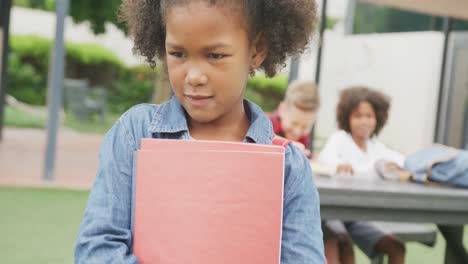 Video-of-sad-biracial-schoolgirl-being-taunted-by-two-boys-in-schoolyard