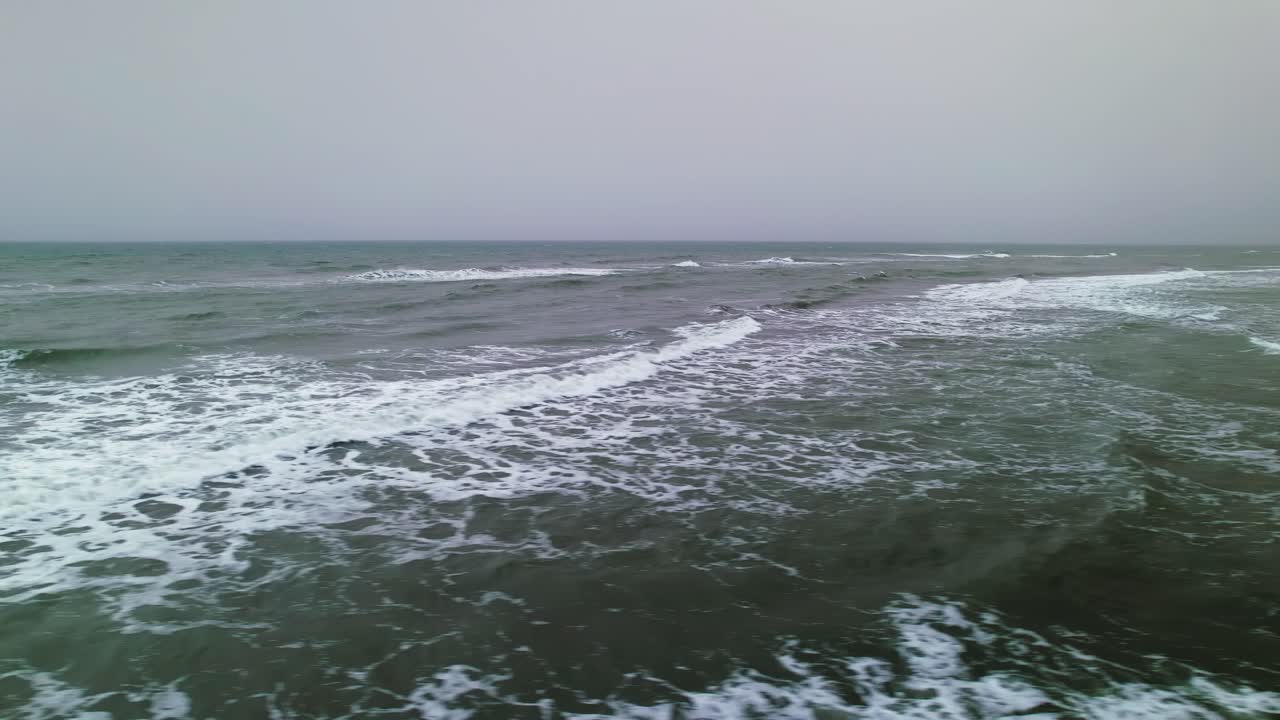 폭풍우 치는 날 해안선을 가로질러 옆으로 날아가는 드론