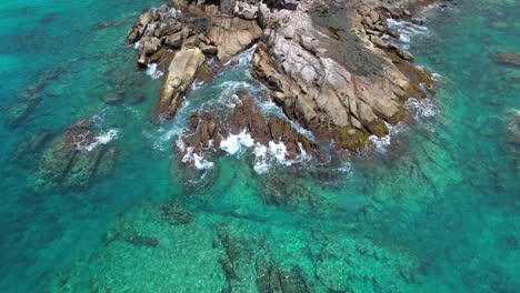 bird eye drone video of huge granite stones near the indian ocean, turquoise transparent water and crushing waves, mahe, seychelles 30fps 1