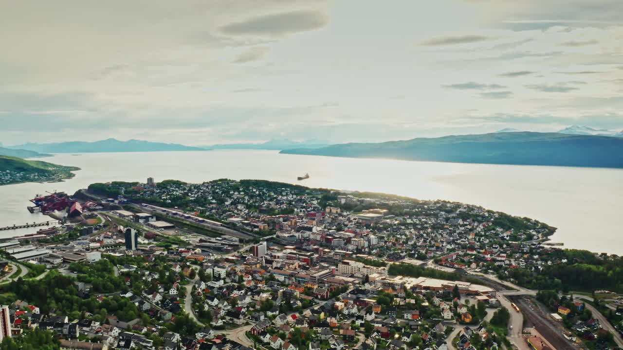 Aerial drone shot over the city of Narvik in Norway. High view of the scenic green landscape, the sea and the nordic fjords.
