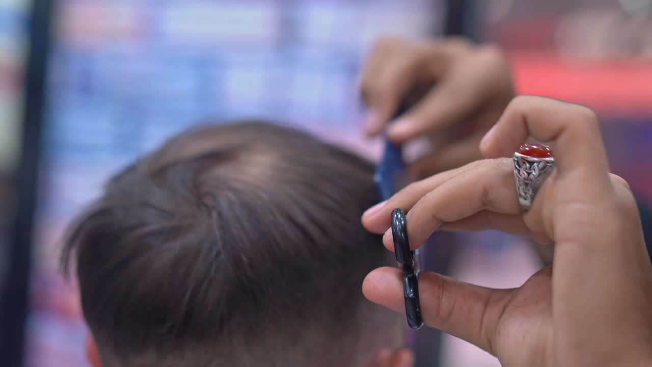 barbero corta el cabello de un hombre con tijeras de cerca