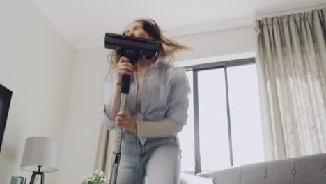 Energetic-woman-dancing-and-vacuum-cleaning