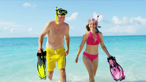 caucasian couple on caribbean beach with snorkeling equipment