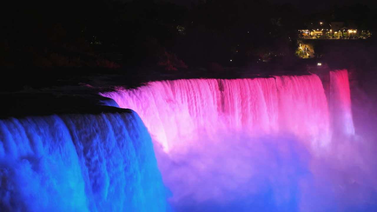 나이아가라의 미국 쪽은 다양한 색상의 스포트라이트 4k 비디오로 밝게 빛납니다.