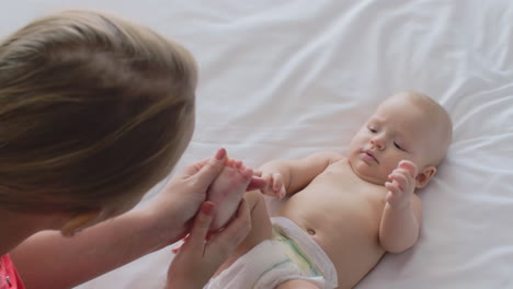 A-woman-massaging-baby-girl-foot-and-playing-with-her