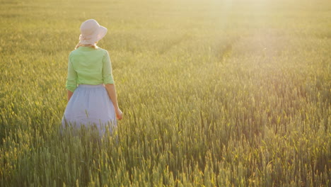 A-Woman-Farmer-Admires-The-Endless-Field-Of-Green-Wheat-Organic-Farming-Concept-4K-Video