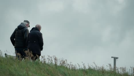 elderly couple together, retirement leisure walking, windy weather