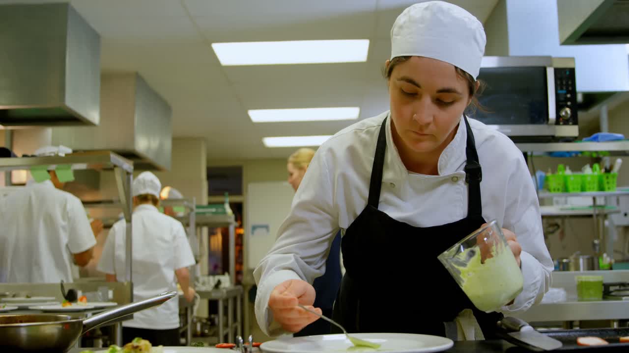 chef femenina sirviendo salsa en un plato de 4k