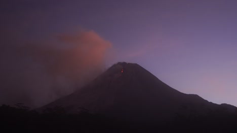 Eines-Nachts-Fließt-Glühende-Lava-Vom-Gipfel-Des-Mount-Merapi-Vor-Einem-Violetten-Himmelshintergrund