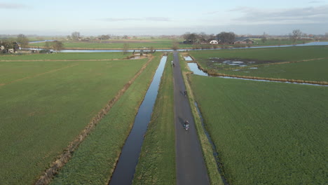 Aerial-of-busy-small-road-surrounded-by-green-meadows