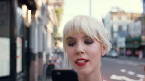 young woman looking at smartphone in city street