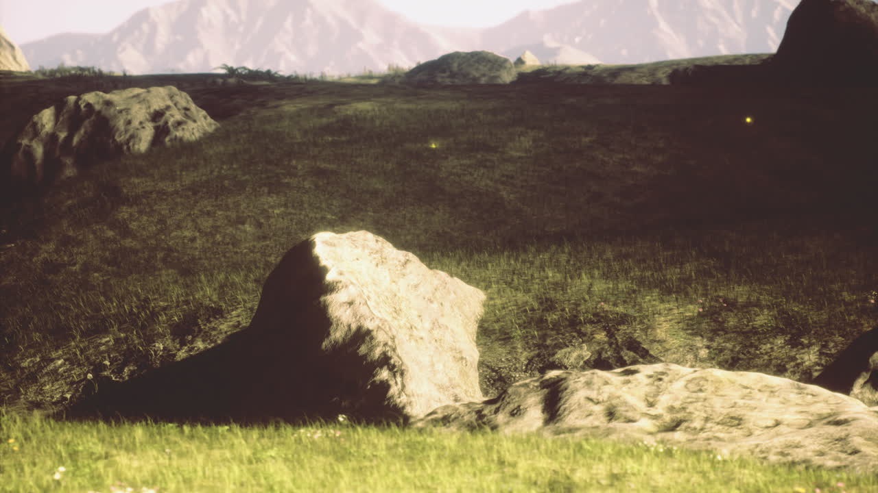 Rocks and grass landscape with mountains in the background during daytime