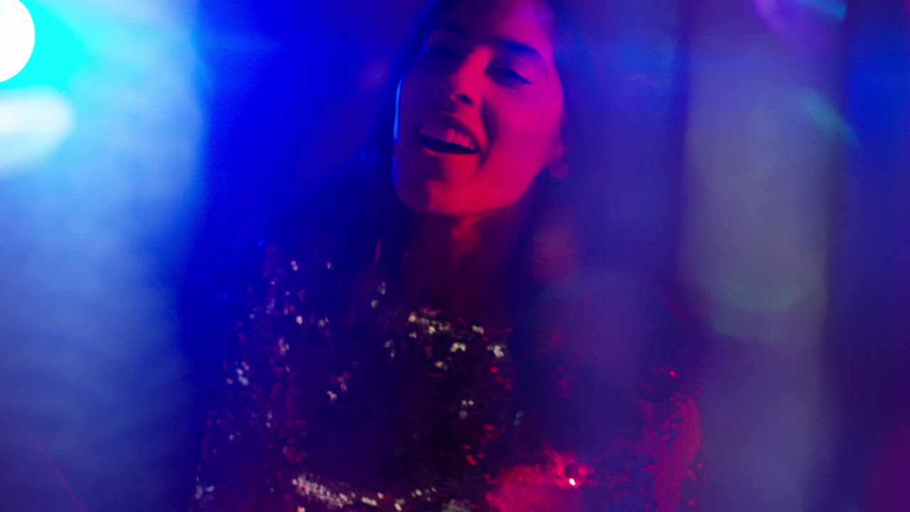 primer plano de una mujer en un bar nocturno o discoteca bailando con luces brillantes 1