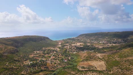 Flying-towards-bay-over-Greek-countryside-with-mountain-landscape