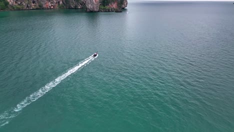 longtail boat cruising across the tonsai bay in krabi, thailand