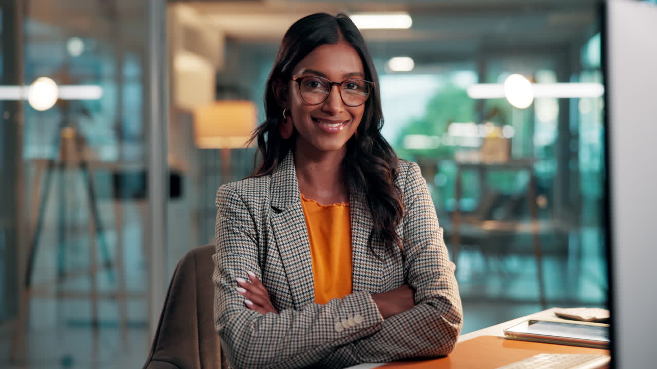 Mulher profissional trabalhando no computador e sorrindo em escritório moderno