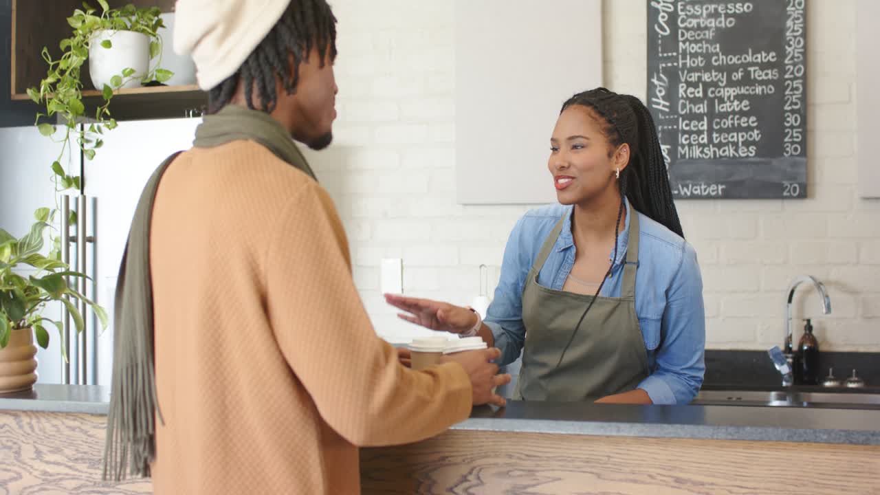 Diverse barista and customer greeting, offering tray, selecting cups, paying for order, copy space