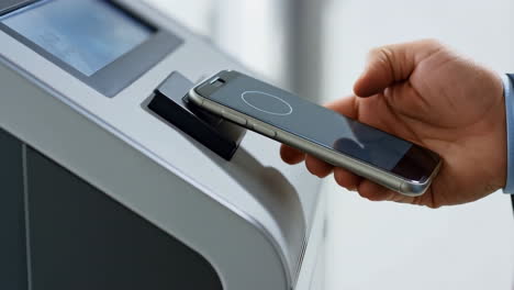 person using a smartphone for contactless payment at a terminal