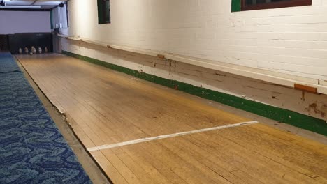 juego tradicional de pub inglés de nueve bolas skittles con la pelota golpeando alfileres de madera en un callejón en somerset, inglaterra, reino unido